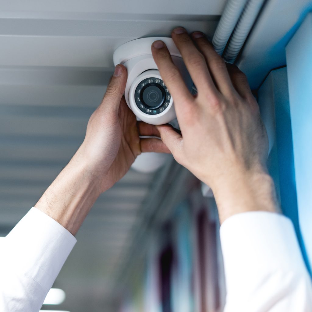 partial view of man setting up security camera